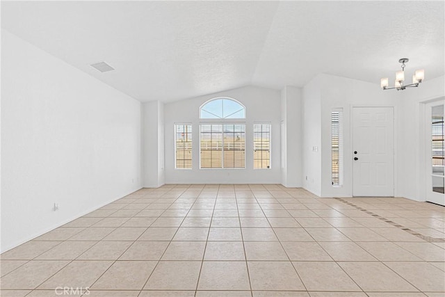 9191 White Rd, Phelan, CA 92371 - foyer with vaulted ceiling, a chandelier, light tile patterned floors, and a textured ceiling