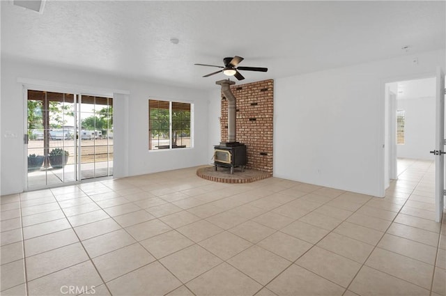 9191 White Rd, Phelan, CA 92371 - unfurnished living room with ceiling fan, light tile patterned floors, and a wood stove