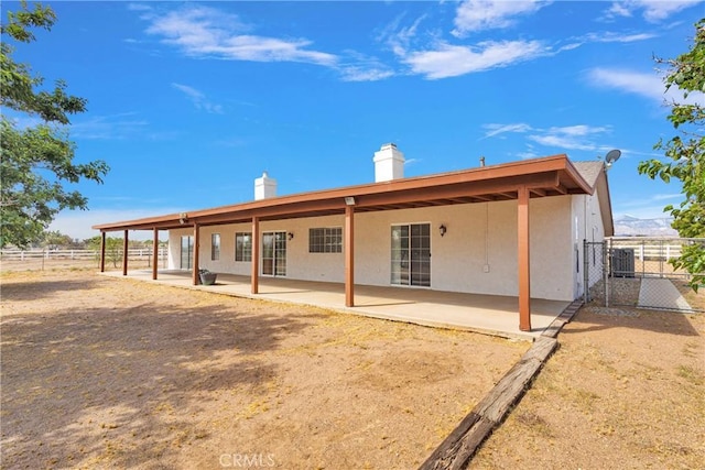 9191 White Rd, Phelan, CA 92371 - rear view of property featuring a patio area, a chimney, and stucco siding