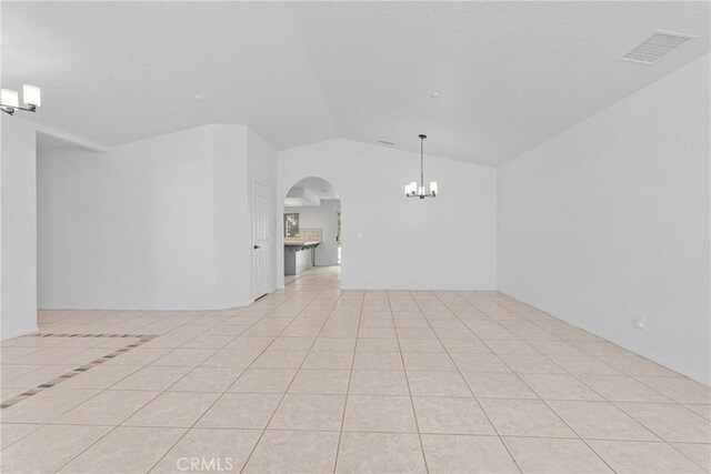 9191 White Rd, Phelan, CA 92371 - spare room with a chandelier, arched walkways, vaulted ceiling, and light tile patterned flooring