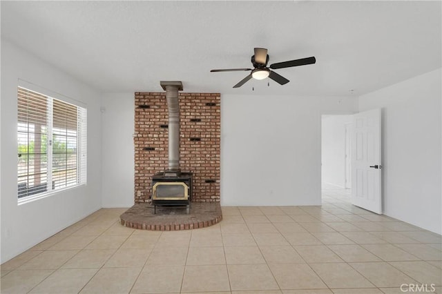 9191 White Rd, Phelan, CA 92371 - unfurnished living room featuring a wood stove, a ceiling fan, and light tile patterned floors