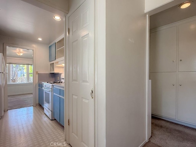 569 Huntington Rd, Cambria, CA 93428 - kitchen with white appliances, blue cabinetry, open shelves, recessed lighting, and range hood