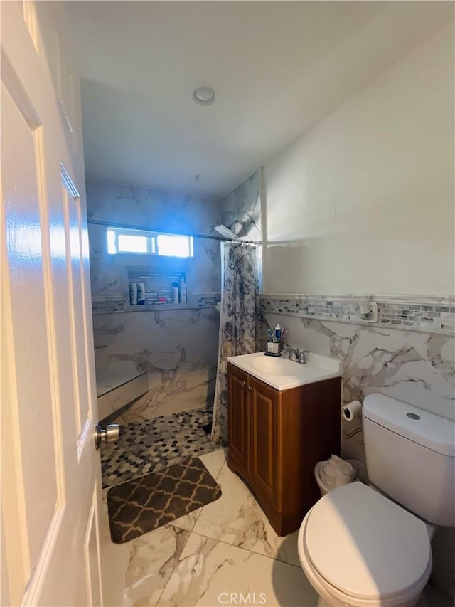 1130 S Rene Dr, Santa Ana, CA 92704 - full bath featuring tiled shower, vanity, tile walls, marble finish floors, and wainscoting
