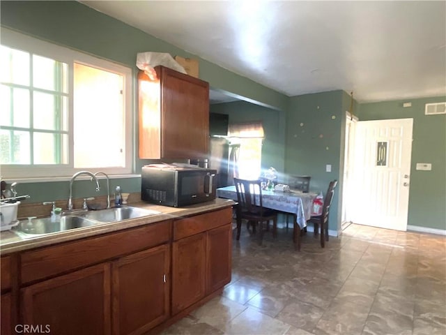 1130 S Rene Dr, Santa Ana, CA 92704 - kitchen featuring black microwave, plenty of natural light, brown cabinets, and light countertops