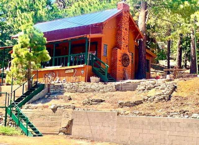 33140 Juniper Ln, Green Valley Lake, CA 92341 - view of front facade featuring stairway, a chimney, and a metal roof