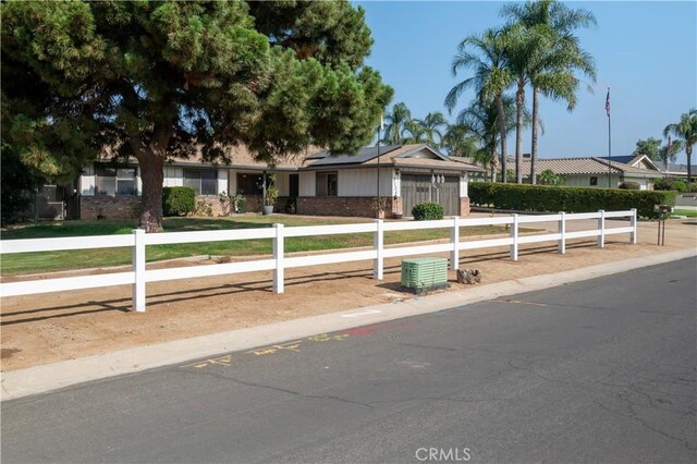3134 Half Circle Rd, Norco, CA 92860 - ranch-style house with roof mounted solar panels, a fenced front yard, and brick siding