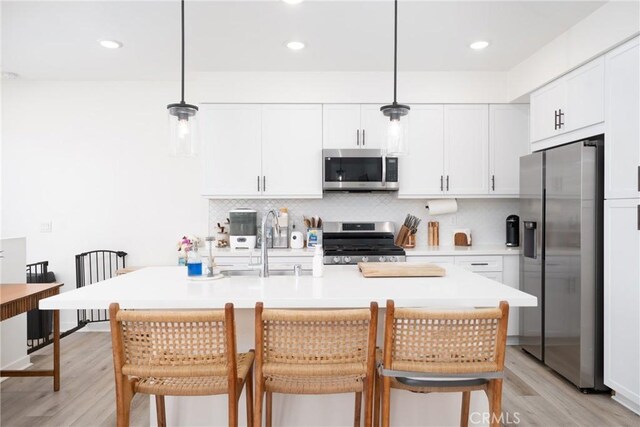 11046 Wander Dr, Rancho Cucamonga, CA 91730 - kitchen featuring stainless steel appliances, light wood-style floors, white cabinetry, decorative backsplash, and recessed lighting