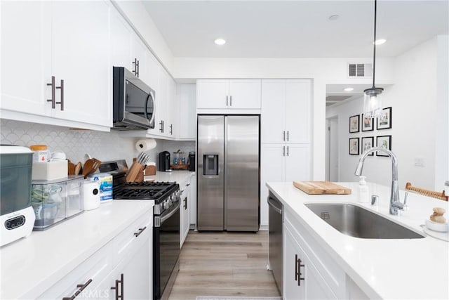 11046 Wander Dr, Rancho Cucamonga, CA 91730 - kitchen featuring stainless steel appliances, light countertops, white cabinets, light wood finished floors, and recessed lighting
