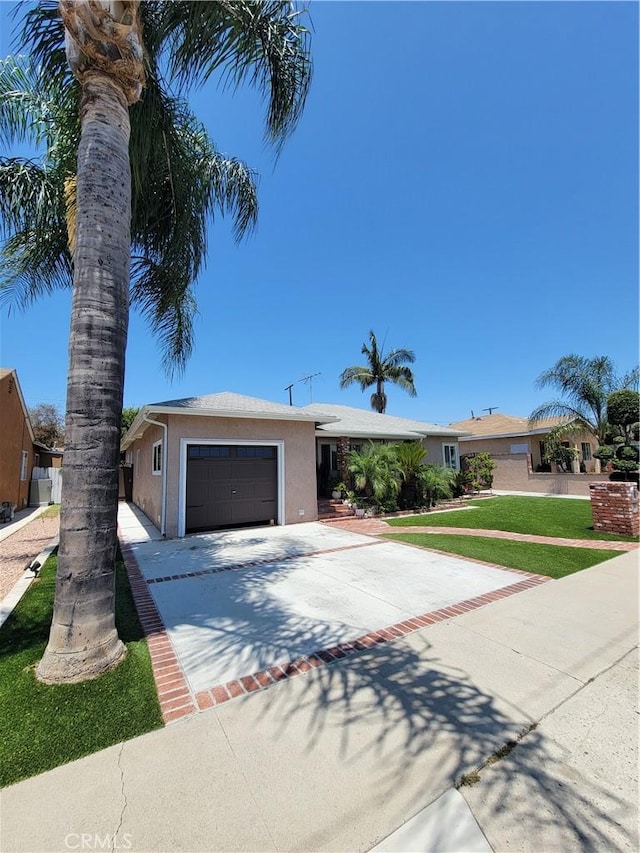 11521 Mclaren St, Norwalk, CA 90650 - ranch-style home with concrete driveway, stucco siding, a garage, and a front lawn