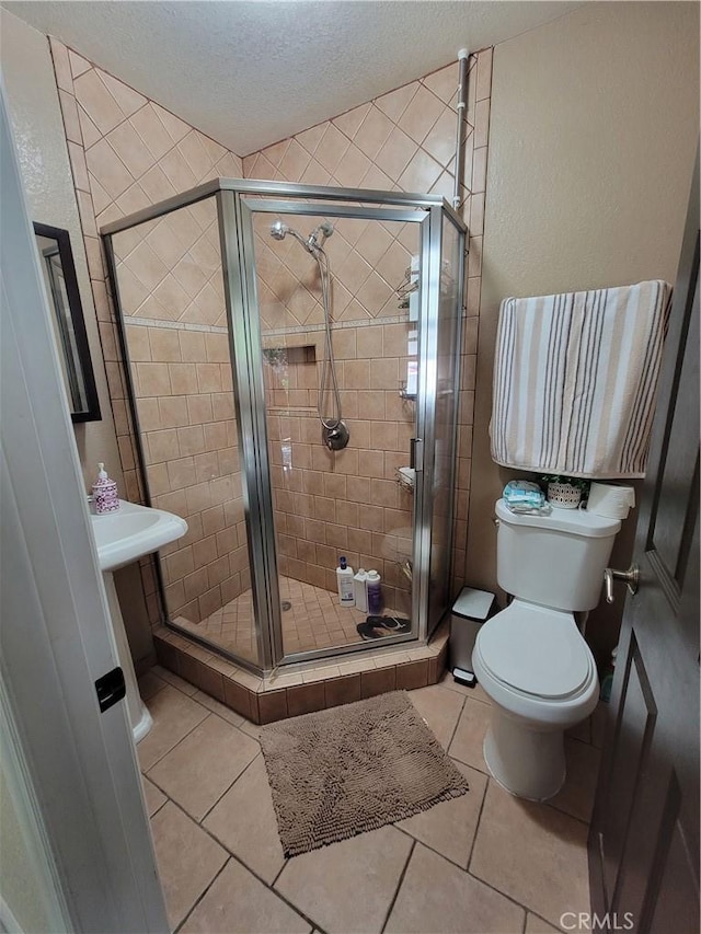 11521 Mclaren St, Norwalk, CA 90650 - bathroom featuring a textured ceiling, tile patterned flooring, and a stall shower