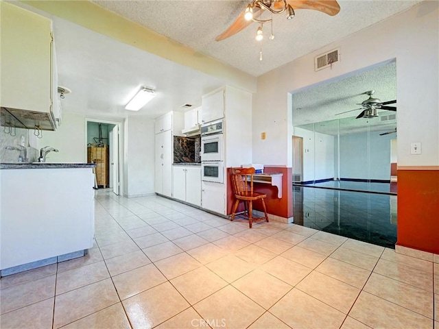 346 E Plymouth St, Glendora, CA 91740 - kitchen with a ceiling fan, a textured ceiling, light tile patterned floors, double oven, and white cabinets