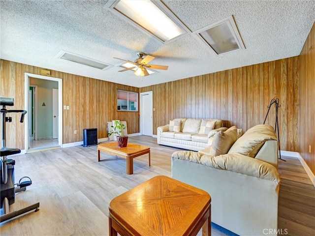 346 E Plymouth St, Glendora, CA 91740 - living room featuring attic access, a textured ceiling, wood walls, ceiling fan, and wood finished floors