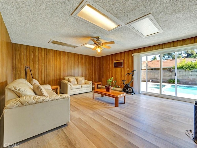 346 E Plymouth St, Glendora, CA 91740 - living room with a textured ceiling, wooden walls, light wood finished floors, and a ceiling fan