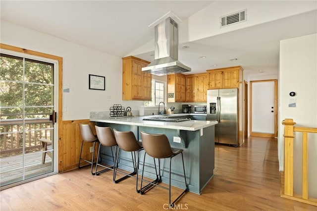 1348 Manzanita Way, Lake Arrowhead, CA 92352 - kitchen featuring appliances with stainless steel finishes, vaulted ceiling, island range hood, a peninsula, and light wood-type flooring