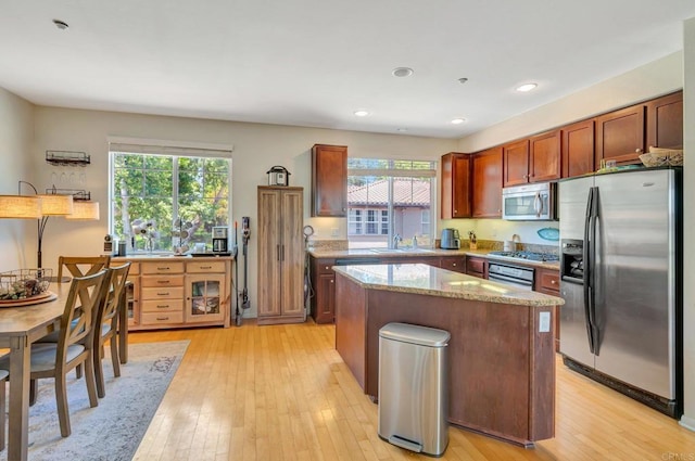 14658 Via Fiesta Unit 2, San Diego, CA 92127 - kitchen with appliances with stainless steel finishes, light stone counters, a center island, light wood-style flooring, and recessed lighting