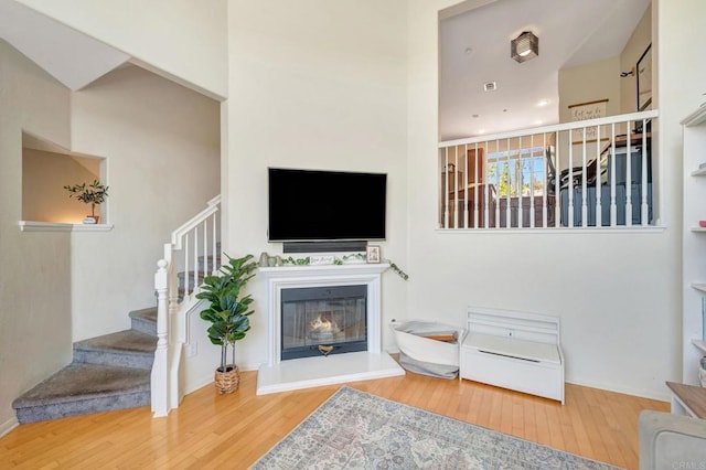 14658 Via Fiesta Unit 2, San Diego, CA 92127 - living area with wood-type flooring, stairs, and a glass covered fireplace