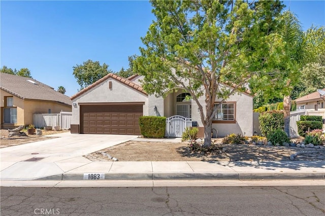1083 Mill Iron Way, San Jacinto, CA 92583 - mediterranean / spanish house with stucco siding, concrete driveway, an attached garage, a gate, and a tiled roof