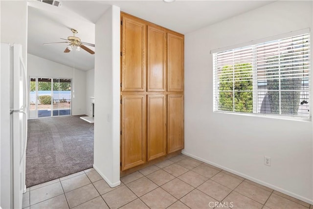 1083 Mill Iron Way, San Jacinto, CA 92583 - unfurnished bedroom featuring freestanding refrigerator, light tile patterned floors, vaulted ceiling, access to exterior, and ceiling fan