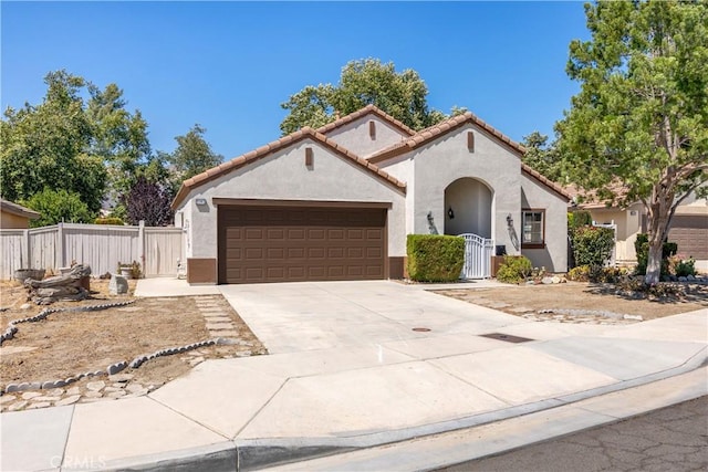 1083 Mill Iron Way, San Jacinto, CA 92583 - mediterranean / spanish house featuring stucco siding, a garage, driveway, a tile roof, and a gate