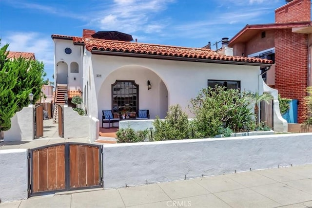 239 Nieto Ave Unit A, Long Beach, CA 90803 - back of house with a fenced front yard, a gate, stucco siding, covered porch, and a tile roof