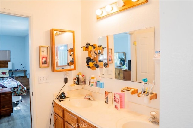 10515 Acoro St, Bellflower, CA 90706 - bathroom featuring double vanity, wood finished floors, and ensuite bath