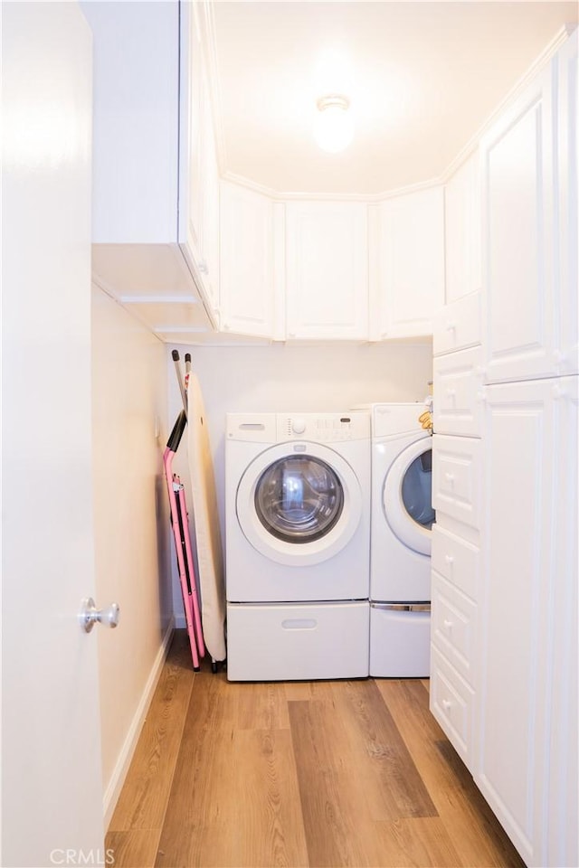10515 Acoro St, Bellflower, CA 90706 - washroom featuring washer and dryer, light wood finished floors, and cabinet space
