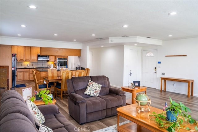10515 Acoro St, Bellflower, CA 90706 - living room with wood finished floors, recessed lighting, and crown molding