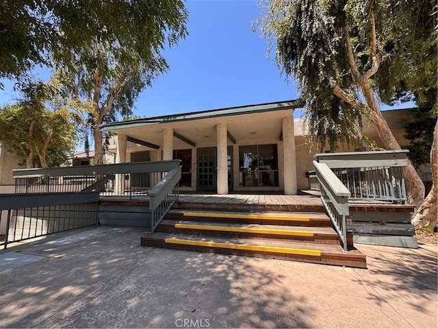 8601 International Ave Unit 178, Canoga Park, CA 91304 - property entrance featuring a wooden deck, stucco siding, and a patio