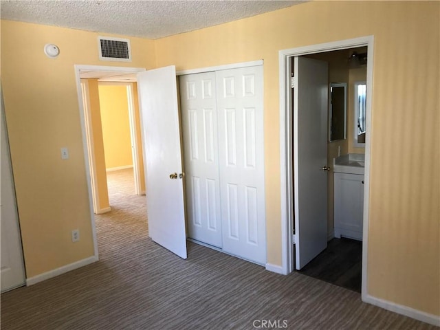 8601 International Ave Unit 178, Canoga Park, CA 91304 - unfurnished bedroom with dark colored carpet, a textured ceiling, and a closet