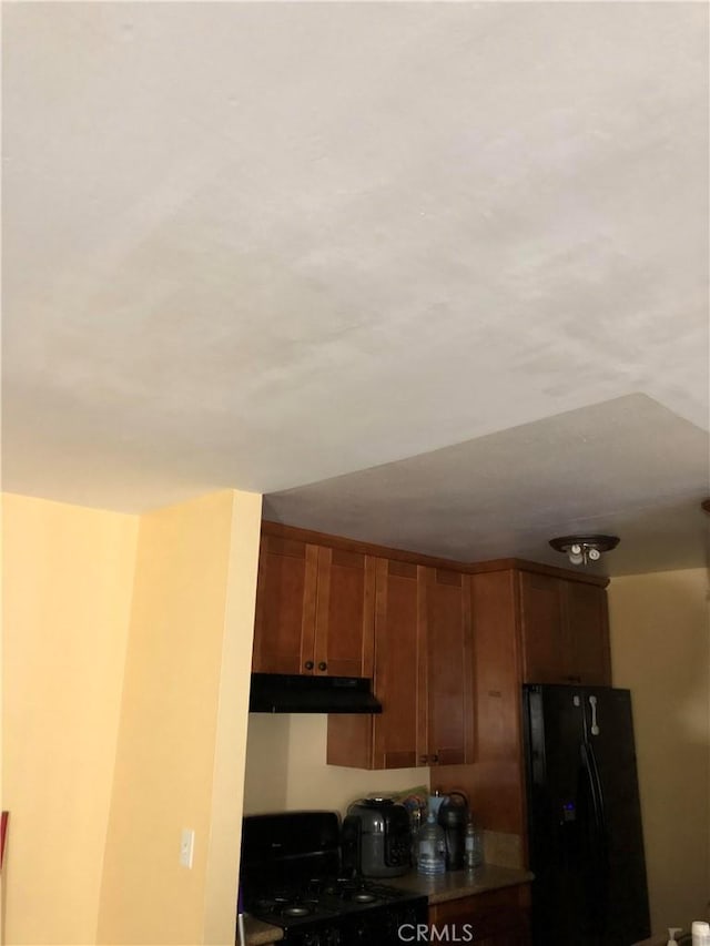 8601 International Ave Unit 178, Canoga Park, CA 91304 - kitchen with black refrigerator with ice dispenser, stove, under cabinet range hood, and brown cabinetry