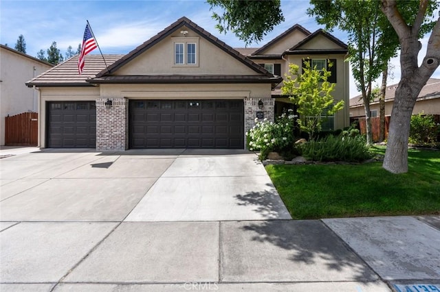 4139 Sunshine Ct, Merced, CA 95340 - view of front facade with stucco siding, brick siding, concrete driveway, and an attached garage