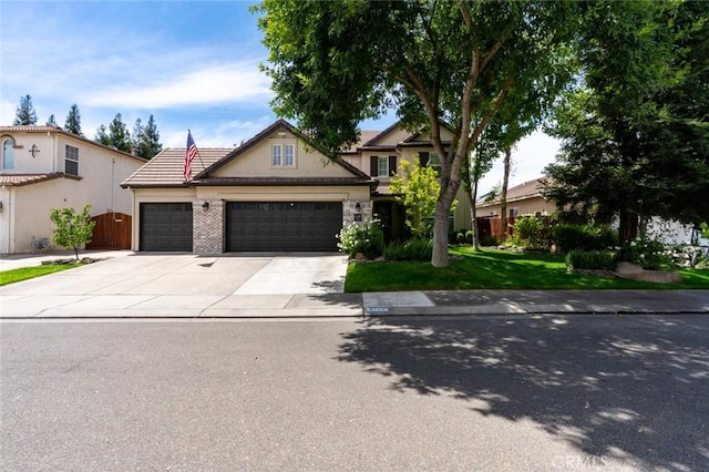 4139 Sunshine Ct, Merced, CA 95340 - view of front of home with a garage, concrete driveway, a front lawn, stucco siding, and a tiled roof