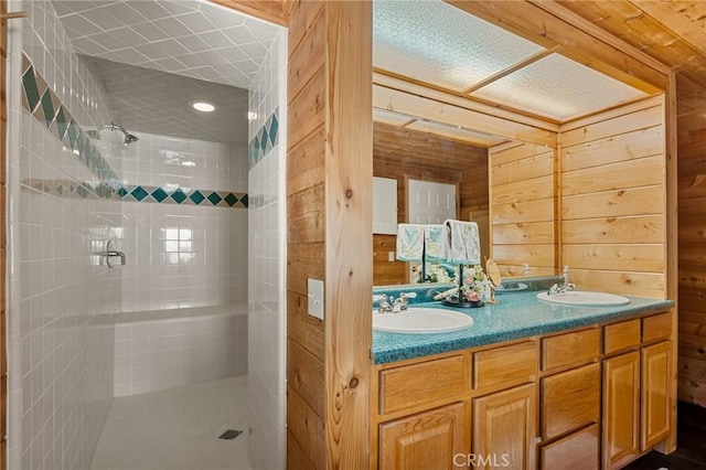 1 Sunny Slope, Running Springs, CA 92382 - bathroom featuring a tile shower, wood walls, and double vanity