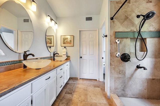 6847 Adolphia Dr, Carlsbad, CA 92011 - bathroom with tiled shower, double vanity, and stone finish floors