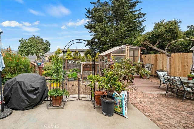 1246 15th St, Los Osos, CA 93402 - fenced backyard with area for grilling, a greenhouse, an outbuilding, a wooden deck, and outdoor dining space