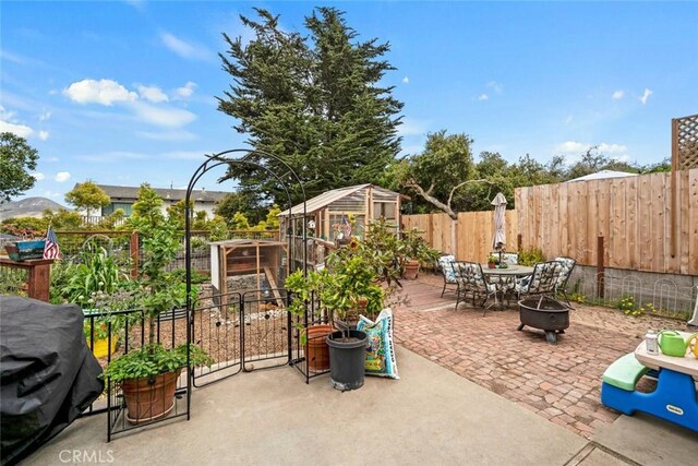 1246 15th St, Los Osos, CA 93402 - fenced backyard featuring an outdoor fire pit, a patio area, and an outbuilding