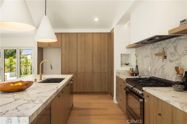 3499 San Rafael Cir, Costa Mesa, CA 92626 - kitchen featuring range with gas stovetop, light wood-style floors, premium range hood, brown cabinetry, and light stone countertops