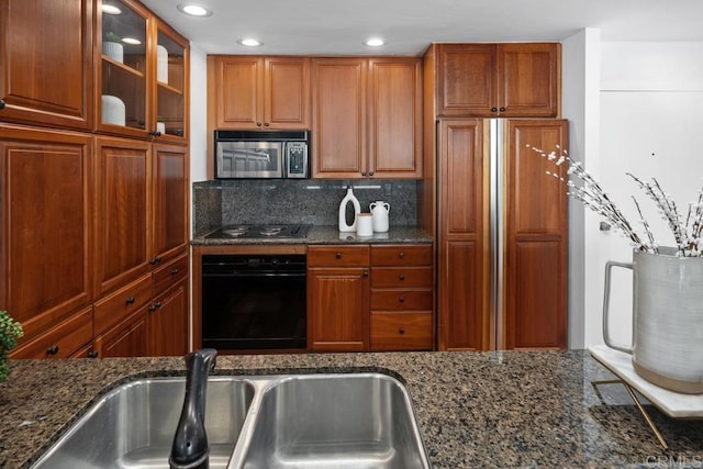 2500 Torrey Pines Rd Unit 1101, La Jolla, CA 92037 - kitchen with black appliances, dark stone countertops, brown cabinets, recessed lighting, and tasteful backsplash