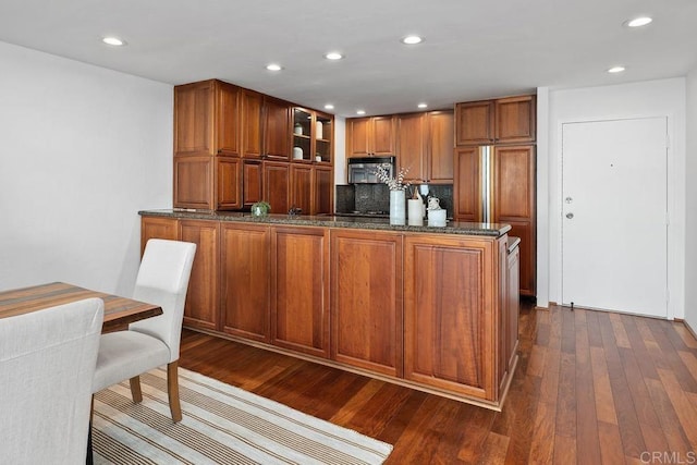 2500 Torrey Pines Rd Unit 1101, La Jolla, CA 92037 - kitchen with stainless steel microwave, dark wood-style floors, dark stone counters, brown cabinets, and recessed lighting