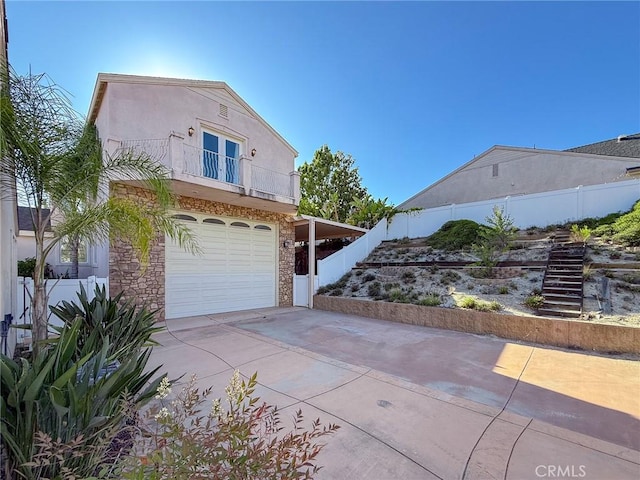 43097 Calle Camellia, Temecula, CA 92592 - view of home's exterior with a balcony, concrete driveway, an attached garage, stone siding, and stairs
