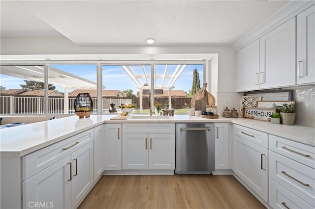 2143 Westminster Dr, Palmdale, CA 93550 - kitchen featuring light wood-type flooring, light countertops, white cabinets, and backsplash