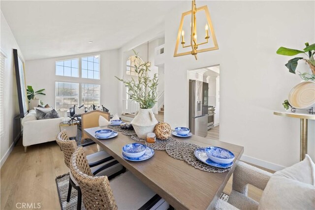 2143 Westminster Dr, Palmdale, CA 93550 - dining area featuring light wood-style floors, a chandelier, and high vaulted ceiling