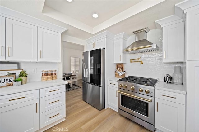 2143 Westminster Dr, Palmdale, CA 93550 - kitchen featuring appliances with stainless steel finishes, wall chimney range hood, light countertops, white cabinetry, and recessed lighting