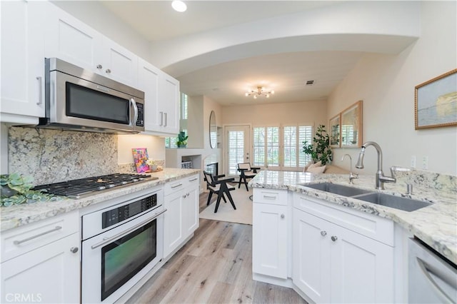 5 Bretagne, Newport Coast, CA 92657 - kitchen featuring appliances with stainless steel finishes, arched walkways, backsplash, and white cabinetry