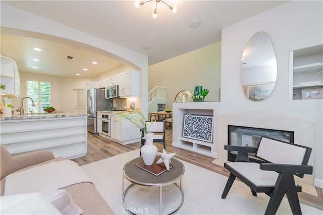 5 Bretagne, Newport Coast, CA 92657 - living area with light wood finished floors, a fireplace, arched walkways, and recessed lighting