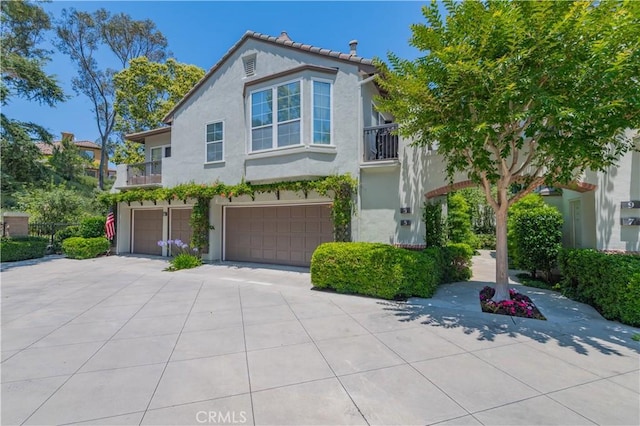 5 Bretagne, Newport Coast, CA 92657 - view of front of house featuring a balcony, an attached garage, driveway, and stucco siding