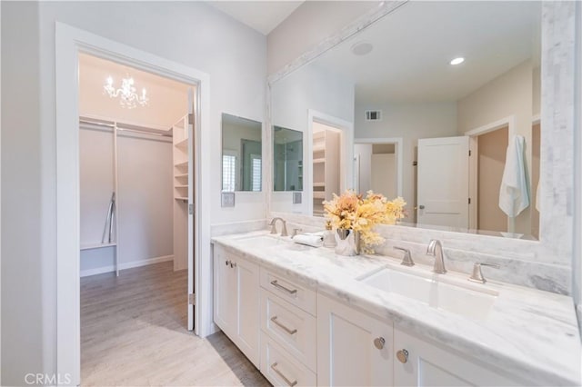 5 Bretagne, Newport Coast, CA 92657 - bathroom with double vanity, wood finished floors, a spacious closet, and a chandelier