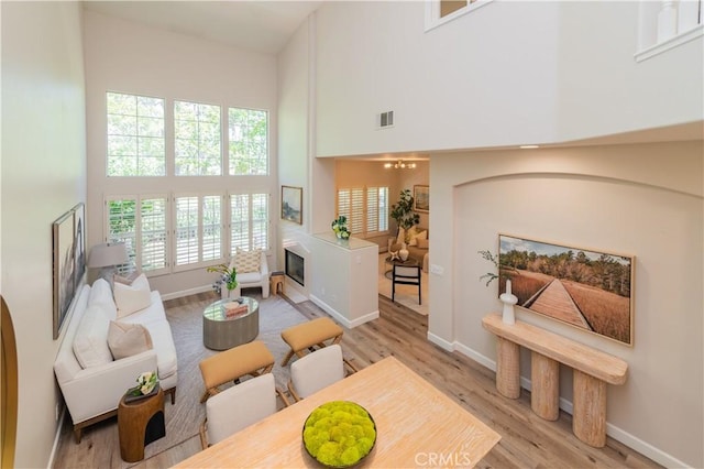 5 Bretagne, Newport Coast, CA 92657 - living area with a high ceiling, light wood-type flooring, and a fireplace