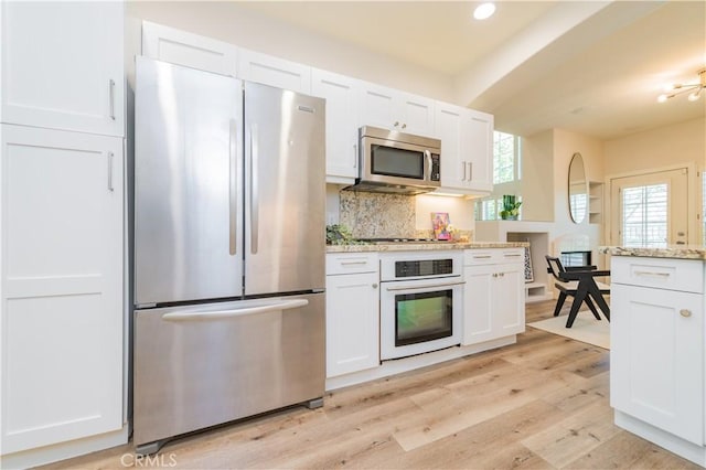 5 Bretagne, Newport Coast, CA 92657 - kitchen featuring appliances with stainless steel finishes, white cabinetry, tasteful backsplash, light wood-style flooring, and recessed lighting