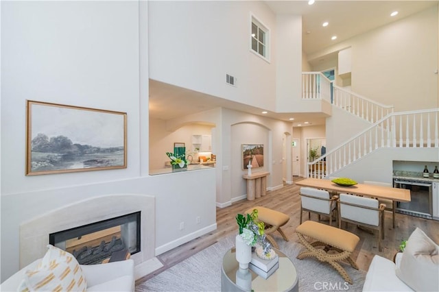 5 Bretagne, Newport Coast, CA 92657 - living room with stairway, wood finished floors, a glass covered fireplace, beverage cooler, and recessed lighting